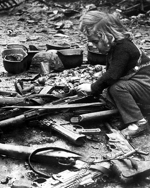 German child playing with abandoned weapons, Berlin, Germany, 1945