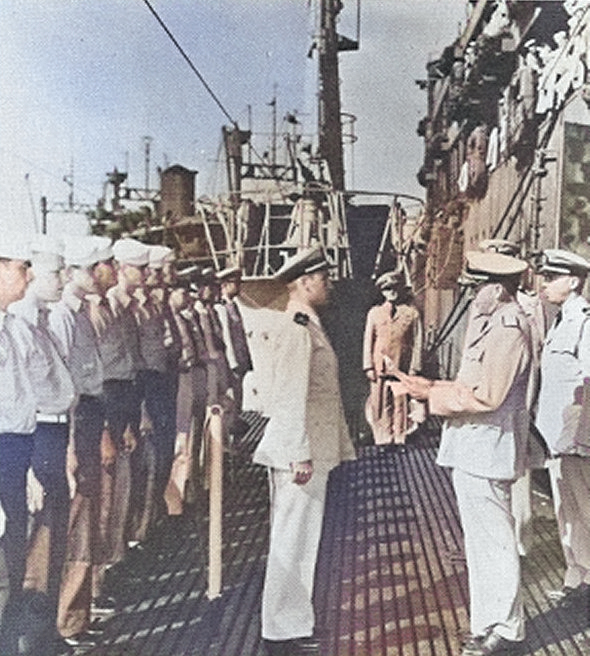 Rear Admiral Ralph Christie, Commander of Submarine Operations in the Southwest Pacific Area, reading the Presidential Citation to the captain and crew of USS Bowfin, Fremantle, Australia, Dec 1943. [Colorized by WW2DB]