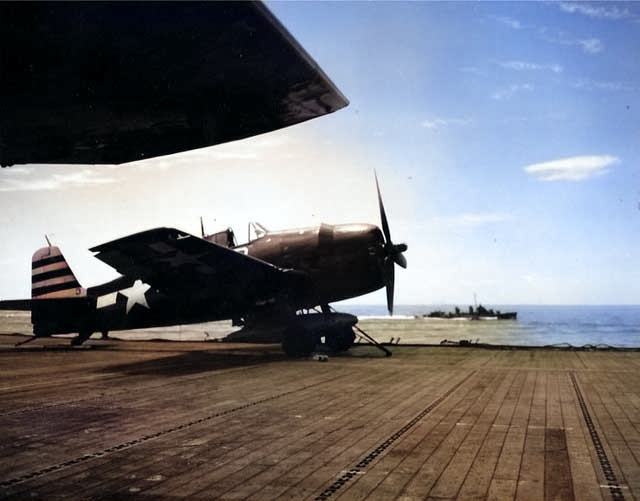 A F6F-5 Hellcat fighter on the port catapult of USS Randolph, Mar 1945; note Geometric Symbol (G-symbol) on tail. [Colorized by WW2DB]