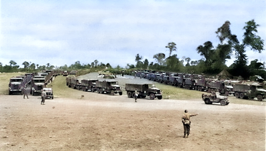 US Army trucks of the 'Red Ball Express' moving through a regulating point, possibly France, circa mid-1944 [Colorized by WW2DB]