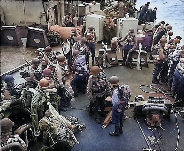 American soldiers in full combat gear on the deck of an United States Coast Guard assault transport in the English Channel, off Normandy, France, 6 Jun 1944 [Colorized by WW2DB]