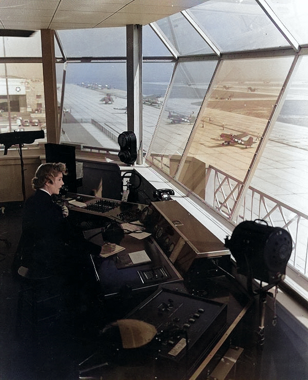 WAVES Control Tower Operator at work at  Naval Air Station, Floyd Bennett Field, New York, United States, Nov 1943; note FM Wildcat and TBM Devastator aircraft in background [Colorized by WW2DB]