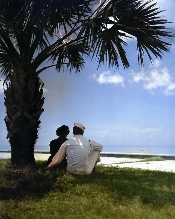 A US Navy sailor and a WAVES member gazing out over the beach at a Gulf of Mexico coast Naval Air Station, United States, circa 1945 [Colorized by WW2DB]