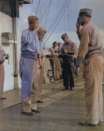 Captain George C. Montgomery awarding the Air Medal to Lieutenant (jg) P. B. Wyser aboard USS Anzio, 6 Jan 1945 [Colorized by WW2DB]