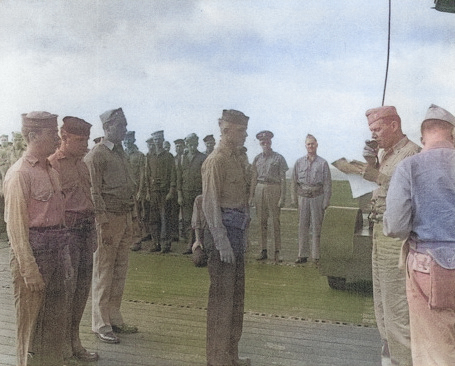 Captain George C. Montgomery awarding a citation ribbon to Aviation Ordnanceman 2nd Class Harvey J. Rowe aboard USS Anzio, 6 Jan 1945, photo 2 of 2 [Colorized by WW2DB]