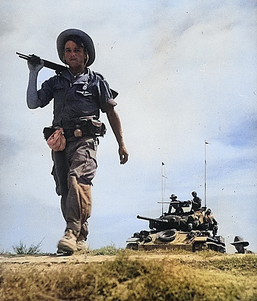 A soldier of the French Foreign Legionnaire in the Red River Delta, between Haiphong and Hanoi, Vietnam, circa 1954; note American-built M24 Chaffee light tank in background [Colorized by WW2DB]