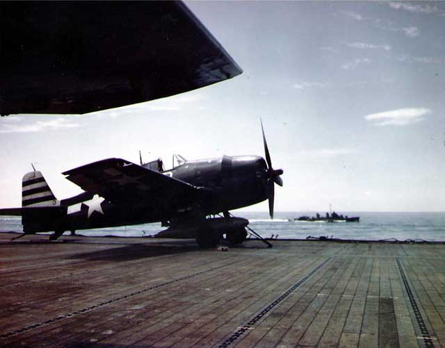 A F6F-5 Hellcat fighter on the port catapult of USS Randolph, Mar 1945; note Geometric Symbol (G-symbol) on tail.