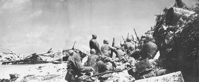 US Marines taking cover behind a barricade on 'Red Beach 3', Betio, Tarawa Atoll, Gilbert Islands, 20 Nov 1943, photo 1 of 2