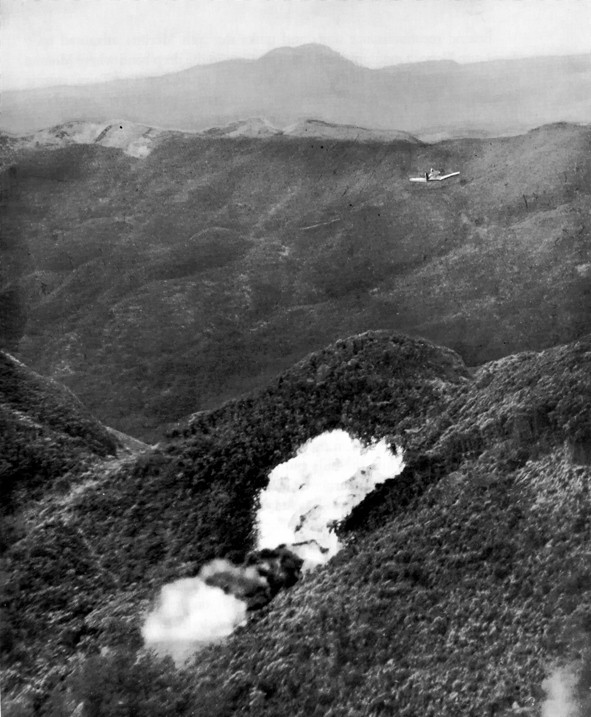 US Marine F4U Corsair fighter dropping a fire bomb on a Japanese position in Northern Okinawa, Japan, circa Apr-Jun 1945