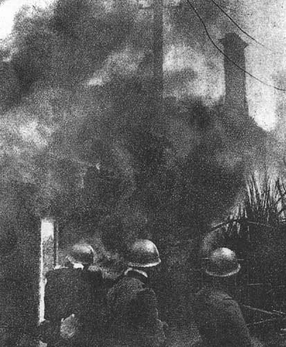 Japanese troops in front of burning buildings, Shanghai, China, 28 Jan 1932