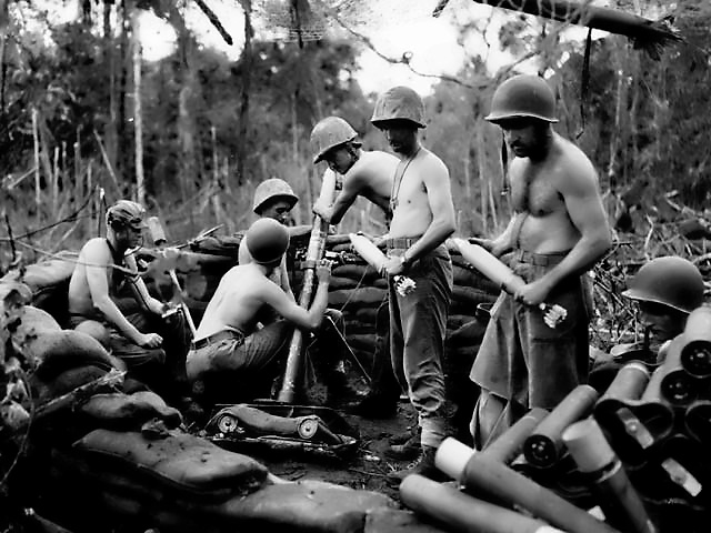 Mortar men of US 1st Marine Division firing against a Japanese artillery position, Cape Gloucester, New Britain, Bismarck Archipelago, circa 15-25 Dec 1943