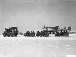 P-38J Lighting “Val” of the 393rd Fighter Squadron sits on the snow covered Saint-Dizier Airfield in France while pilots are delivered to their planes in an unusual manner, Jan 1945