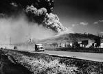 Mt. Vesuvius spewing ash into the sky, erupting as a U.S. Army jeep speeds by shortly after the arrival of the Allied forces in Naples, Italy, late March 1944.