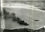 Japanese freighters Shoei Maru beached and burning and Takebe Maru damaged and trailing oil on the coast of French Indochina (Vietnam) north of Qui Nhon after being attacked by 175 USN carrier planes, 12 Jan 1945.