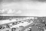 Corsair fighters taxi down the runway at Orote Field, Guam, Marianas, 1944-45. Note F6F Hellcats lining the runway in the foreground and TBM Avengers on the far side.