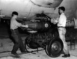 US Navy sailors attach Mk 47 aerial depth charges to the underside of a K-class blimp control car at NAS Weeksville, North Carolina, United States, 1943-44.