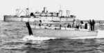 LCVP landing craft from Amphibious Transport Ship USS Hunter Liggett (background) during amphibious training near San Diego, California, United States, circa 1944. Note the LCVP’s unusual raised coxswain podium at the stern