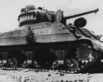 A wrecked M4 Sherman tank showing a shell hit on its outer wooden timbers, Iwo Jima, 15 Mar 1945.