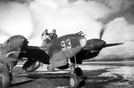 Lt Herb Hasenfus of the 54th Fighter Squadron standing in the cockpit of his P-38 Lightning during engine run-up at Adak, Alaska, Mar 1943. Note the artwork on the engine cowls.