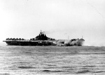 USS Intrepid smoking and listing after being struck by a Japanese special attack aircraft off Okinawa, 16 Apr 1945.