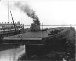 As work finishes up on the side-wheel aircraft carrier USS Wolverine, work begins on converting the Greater Buffalo, left, into the second side-wheel aircraft carrier USS Sable, Buffalo, New York, United States, Aug 1942