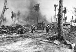 Soldiers of the US Army 7th Division moving a 37mm M3 anti-tank gun by hand to follow behind an M4 Sherman tank on Kwajalein, Marshall Islands, Feb 1944. Note the visibility panels worn by the gun crew.