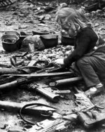 German child playing with abandoned weapons, Berlin, Germany, 1945