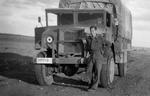 British driver posing with his Canadian Chevrolet-built CMP 4x4 truck in the North African desert, circa 1942.