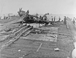 What is left of an SB2C Helldiver on the heavily damaged flight deck of the USS Randolph after a P1Y Ginga special attack bomber crashed into the ship while at anchor in Ulithi Lagoon, Caroline Islands, 11 Mar 1945.