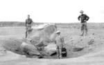 Tai Sing Loo, center with camera, with volcano scientists Emerson and Stokes and an 8-10 ton rock thrown 1 kilometer by the Kilauea eruption of 18 May 1924.  22 May 1924 photo, Kilauea, Hawaii.