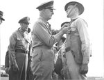 Lieutenant General Delos Emmons decorating an enlisted man for actions performed during the Japanese attack on Pearl Harbor. Hickam Field, 23 Dec 1941. Major General Clarence Tinker looking on.