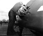 Ordinancemen load .50 caliber ammunition into the wing mounts of an F6F Hellcat while the wings are folded aboard the USS Enterprise southeast of Okinawa, 10 Oct 1944.