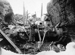 United States Marine inspecting an abandoned Japanese Type 95 light tank on Iwo Jima, Japan, Mar 1945.