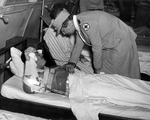 First lady Eleanor Roosevelt visiting combat wounded in a United States Navy field hospital at Espiritu Santo, New Hebrides during her tour of the South Pacific on behalf of the Red Cross, 14 Sep 1943.