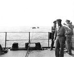 Captured German submarine U-505 with salvage crew on deck (distance) being taken under tow by fleet tug USS Abnaki (foreground), 7 Jun 1944, mid-Atlantic.