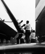 Ordnancemen aboard USS Hancock loading 5-inch HVAR rockets onto the wings of F4U Corsairs before taking off for a strike on Kyushu, Japan, 21 Mar 1945. Photo 2 of 2.