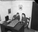 Film director Flight Lieutenant J. E. Boulting and WAAF Leading Aircraftwoman Doreen North discussing the set-up of a shot in a scene at a railway station from 