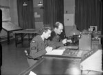 Flying control officer Pilot Officer R. P. Burrows and his WAAF assistant sending barometric pressure data to landing aircraft, RAF Linton-on-Ouse, North Yorkshire, England, United Kingdom, 1942-1945