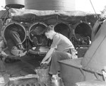 Sailors cleaning 21-inch torpedo tubes aboard USS Nicholas following action on 6 Jul 1943.