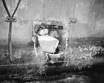 Shipfitter 3rd-class D.R. Cole looks through a hole in USS Honolulu’s stern made by a Japanese torpedo that did not explode, 13 Jul 1943 during the Battle of Kolombangara. Photo taken at Tulagi.