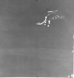 View from a USAAF B-17 bomber of Japanese destroyers Amatsukaze (center, sailing at speed) and Tokitsukaze (top right, slowly backing away from the carrier) evacuating crew of the disabled carrier Ryujo (top center, immobile), Battle of the Eastern Solomons, 24 Aug 1942; note heavy cruiser Tone underway at right edge of the photograph, photo 2 of 2