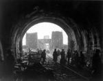 Men of the First US Army in the Erpeler Ley tunnel, Erpel, Germany, 11 Mar 1945; note two wrecked Jeeps and Ludendorff Bridge in background