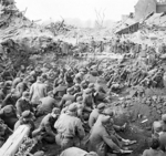 Large group of German prisoners of war sitting together in a compound after being captured by the Western Allies, 25 Mar 1945