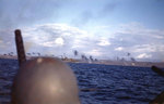 Helmeted crewman in a landing craft watched as a Fletcher-class destroyer shelled Iwo Jima, 19 Feb 1945