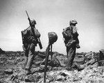 Two Americans walked by a temporary grave of a fellow Marine made of the fallen