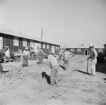 Men digging drainage ditches between barracks buildings, Jerome War Relocation Center, Arkansas, United States, 17 Nov 1942