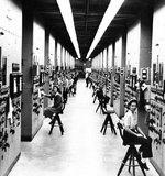 Control panels and operators for calutrons at the Y-12 Plant in Oak Ridge, Tennessee, United States; the woman closest to the camera was identified as Gladys Owens