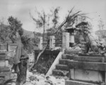 A US Marine having a moment of relaxation with a lion statue, Saipan, Mariana Islands, 27 Jul 1944