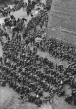 Japanese soldiers resting at the base of the old city wall, Baoding, Hebei, China, circa late 1937 to early 1938