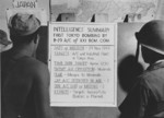 US airmen reading a bulletin announcing their Saipan, Mariana Islands-based unit